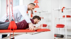 Physiotherapist doing spine treatment with suspension equipment for a man